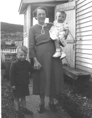 436: Mrs. Mae (Dunphy) Ryan with her grandchildren Lennie and Judy Ryan, by Frank Ryan's  house. Houses in back are Garrett &amp;amp; Mary Lambe's (left) and James &amp;amp; Kit Lambe's  (right). (circa 1951) [courtesy of Elizabeth (Barry) Ryan]  - Mrs. Mae daughter of Patrick Dunphy &amp;amp; Elizabeth Byrne, married Denis Ryan;  Lennie and Judy children of Francis Ryan &amp;amp; Elizabeth Barry